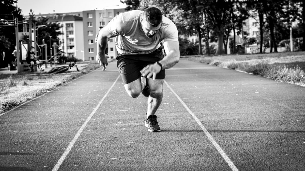 man in gray long sleeve shirt and black shorts running on road during daytime